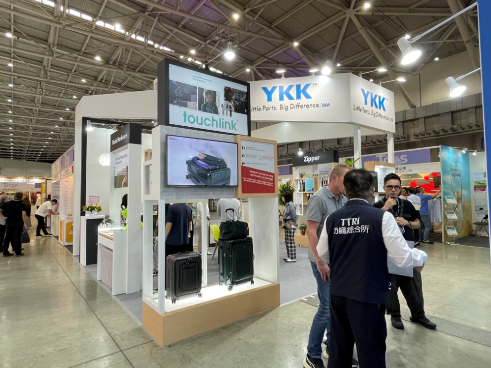 TITAS 2023台北紡織展的YKK展覽攤位，由興隨興展覽公司打造，使用高效能的照明系統，搭配環保材料搭建