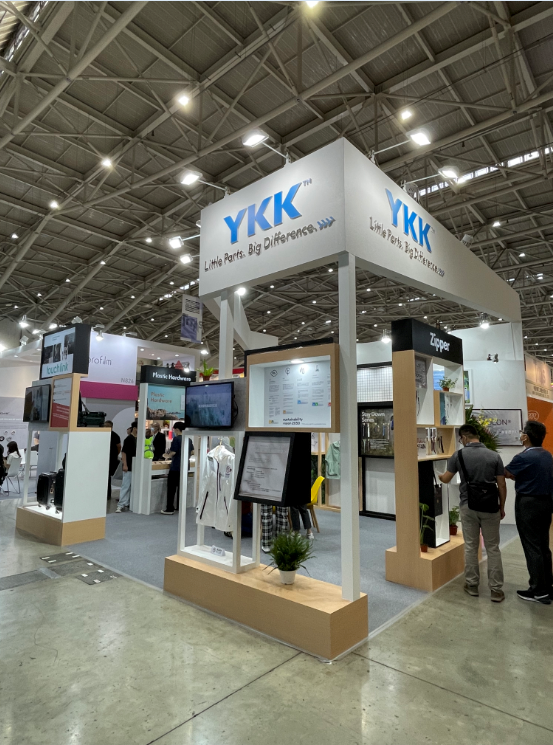TITAS 2023台北紡織展的YKK展覽攤位，由興隨興展覽公司打造，使用高效能的照明系統，搭配環保材料搭建